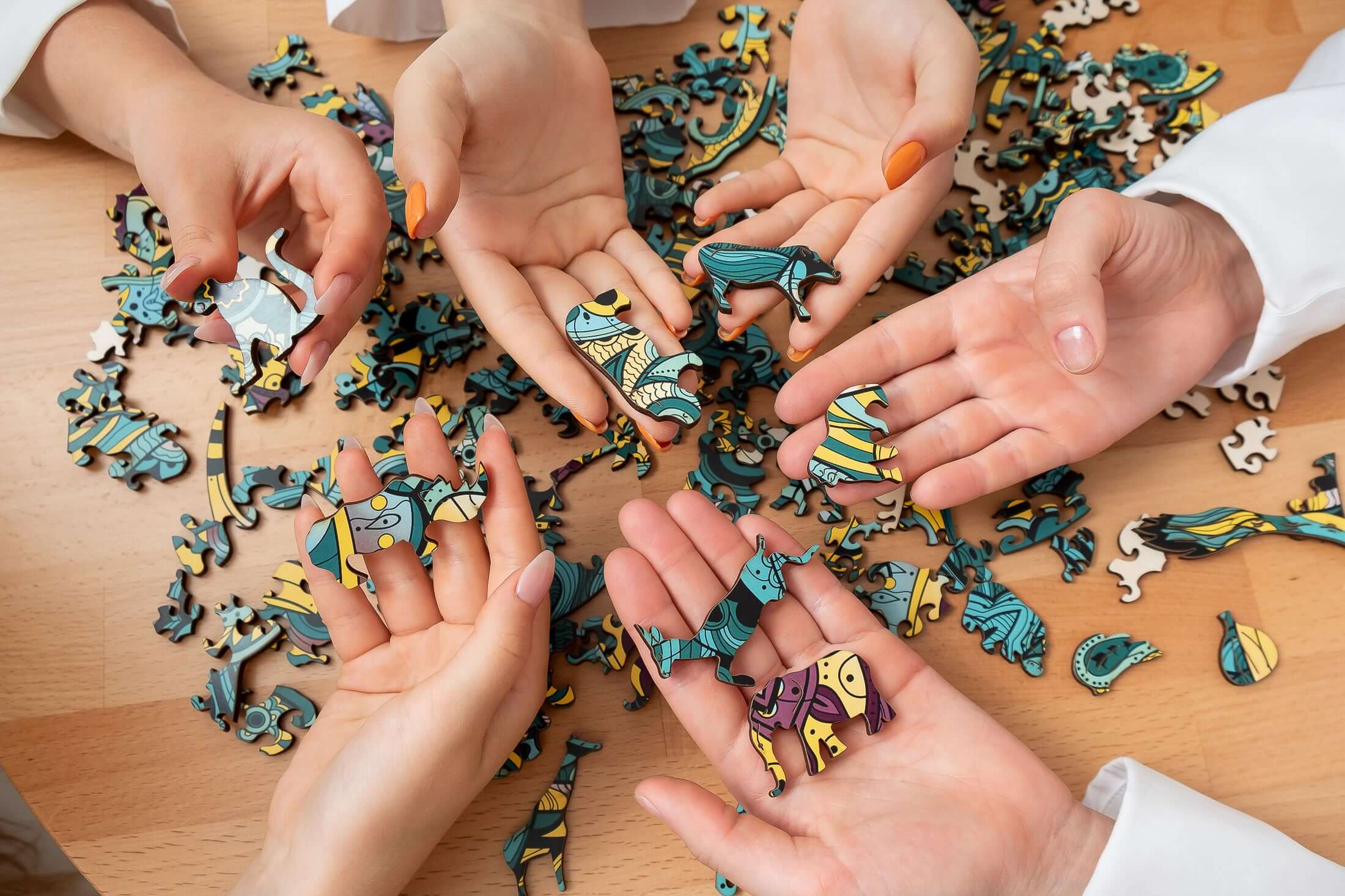 Wooden puzzle pieces holded with a few hands